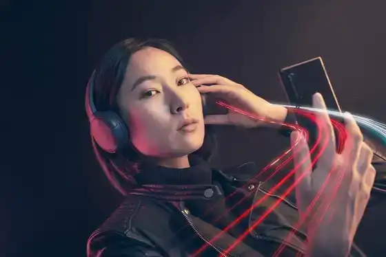 Femme avec casque et smartphone sous lumière néon